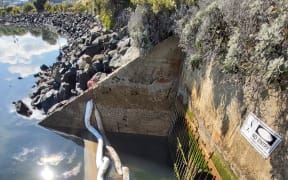 Booms in place at Andersons Bay outlet to stop the spread of diesel into the harbour.