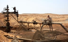 A member of the Syrian government forces stands next to a well at an oil field near Palmyra after retaking it from IS in March 2015.