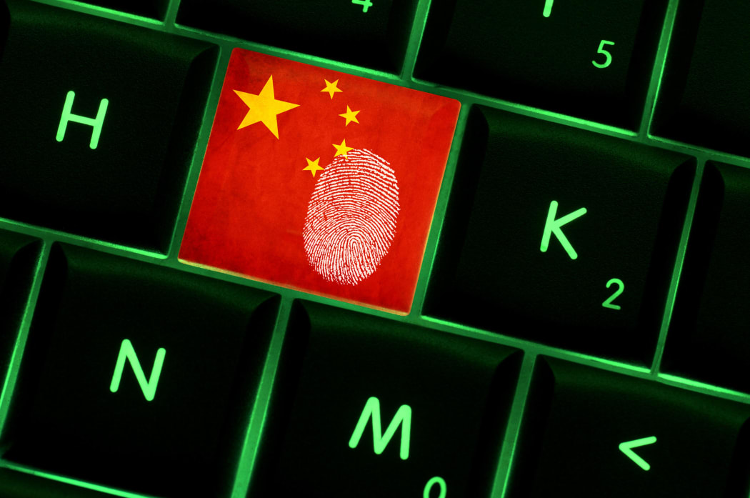 Online crime scene with a finger print left on backlit keyboard with Chinese flag on it
