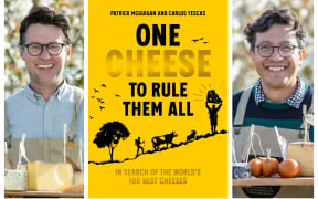 Patrick McGuigan & Carlos Yescas both hold a wooden tray full of different types of cheese. The book cover for 'One Cheese to Rule Them All' is laid out between them.