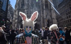 People stroll down New York City's 5th Avenue in the annual Easter Bonnet Parade, in front of St. Patrick's Cathedral.