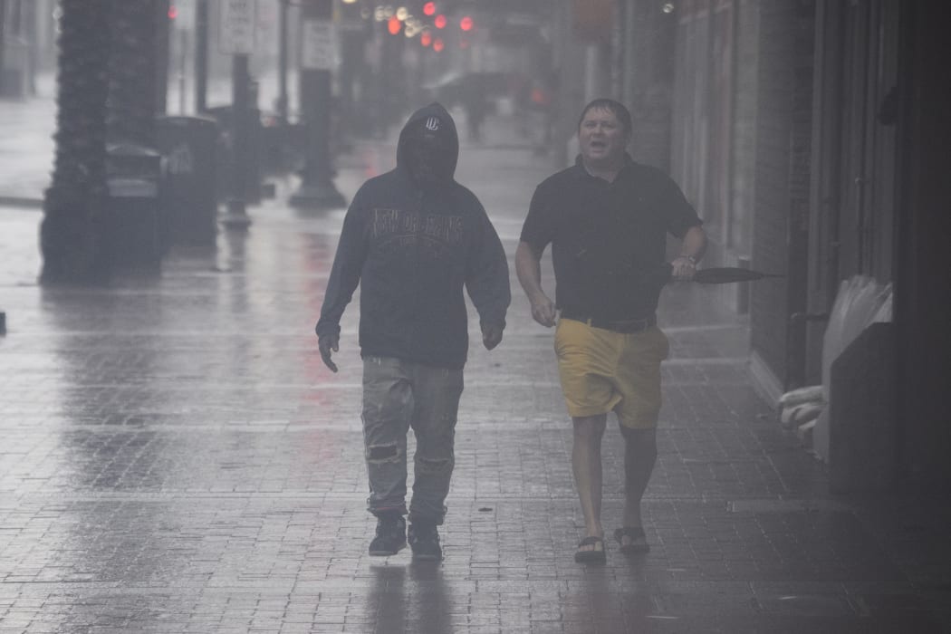 People walk on Canal Street in New Orleans, Louisiana on 29 August 2021 during Hurricane Ida.