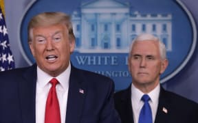 President Donald Trump is flanked by Vice President Mike Pence while speaking during a news briefing on the latest development of the coronavirus outbreak in the US at the White House on 18 March.