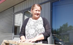Michelle McIlroy stand on the balcony of her temporary home.