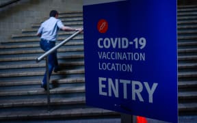 A man walks past signage at a Covid-19 vaccination hub at the Brisbane Convention and Exhibition Centre.