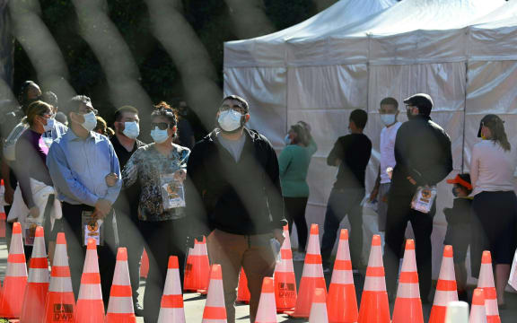People wait in long lines for covid tests at a walk-up Covid-19 testing site in San Fernando, California.