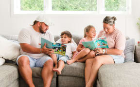 A whānau reading Poppy and Buddy books