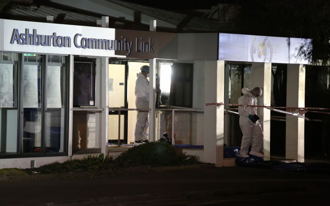 Members of the police forensics team leave the Ashburton Work and Income office, where three women were shot, two fatally.