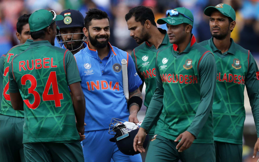 India's batsman Virat Kohli (C) is congratulated by Bangladesh players after winning the ICC Champions Trophy semi-final