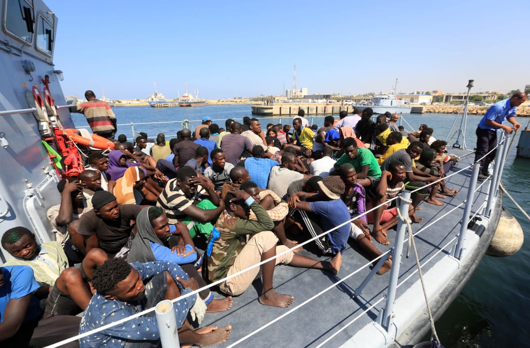 Illegal migrants from Africa sit on a Libyan coastguard boat as they arrive at a naval base in Tripoli after being rescued in the Mediterranean Sea, off the Libyan coast.