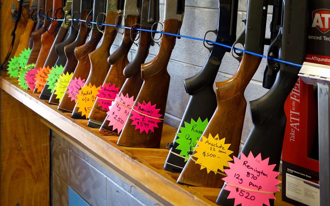 Rifles standing upright in rack with flouro price tags