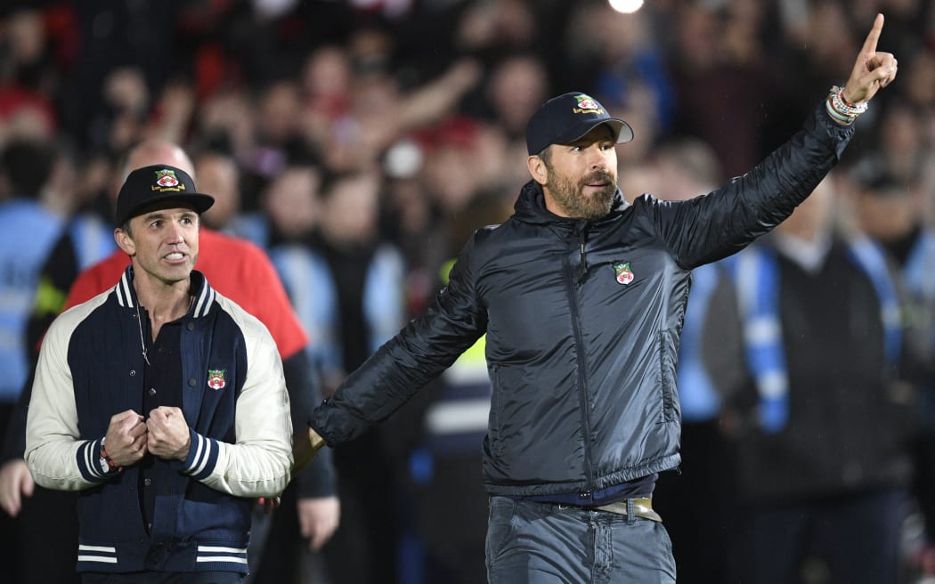 US actors and Wrexham owners Rob McElhenney, left, and Ryan Reynolds celebrate after their team won through to the English Football League after beating Boreham Wood, on 22 April, 2023.