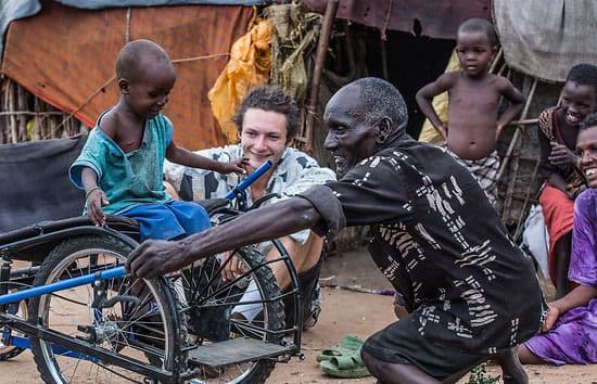 Janna's friend Letu, who has been disabled by polio since birth, shows a child his SafariSeat