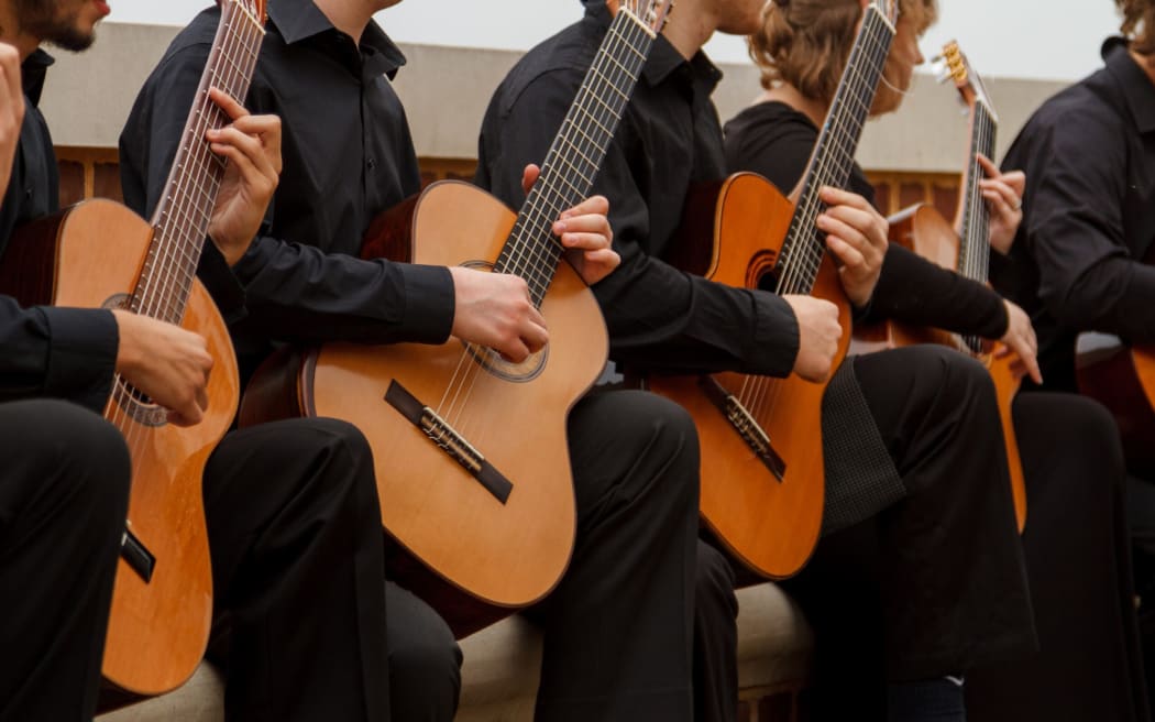 Row of classical guitarists playing guitars