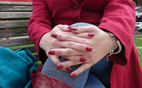 close up of hands as women sits on bench outside