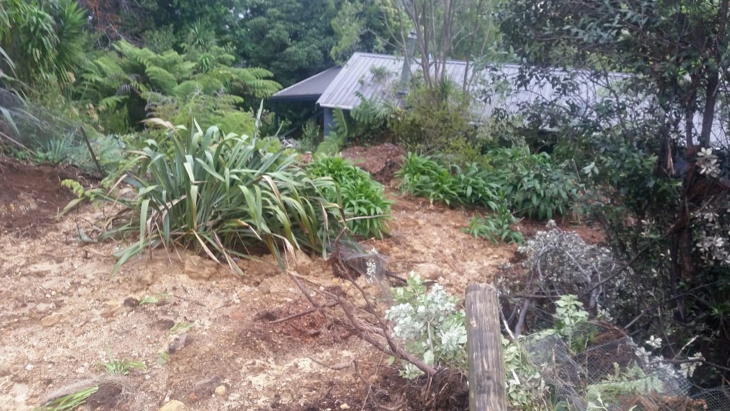 A slip nearly up to the roof of a holiday home in Whangamata, Coromandel Peninsula. The house is holding the mud back from moving onto the street.