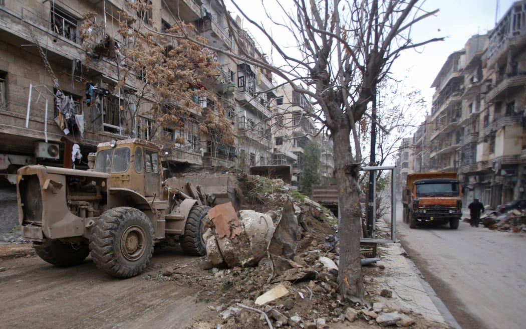 A bulldozer removes rubble from a road as Syrian pro-government forces re-open a street in Aleppo's old city that was formerly barricaded, dividing the government-held and rebel-held areas on December 17.