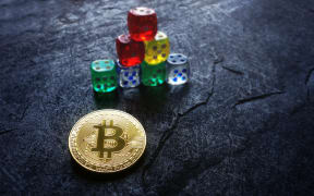 Gold bitcoin and stacked dice -- cryptocurrency investing and risk concept