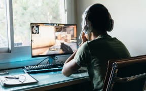 Teenager playing Counter Strike Global Offensive video game on PC. CSGO is an online multiplayer video game developed by Valve