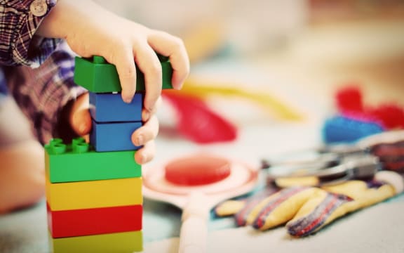 Kid playing with coloured blocks