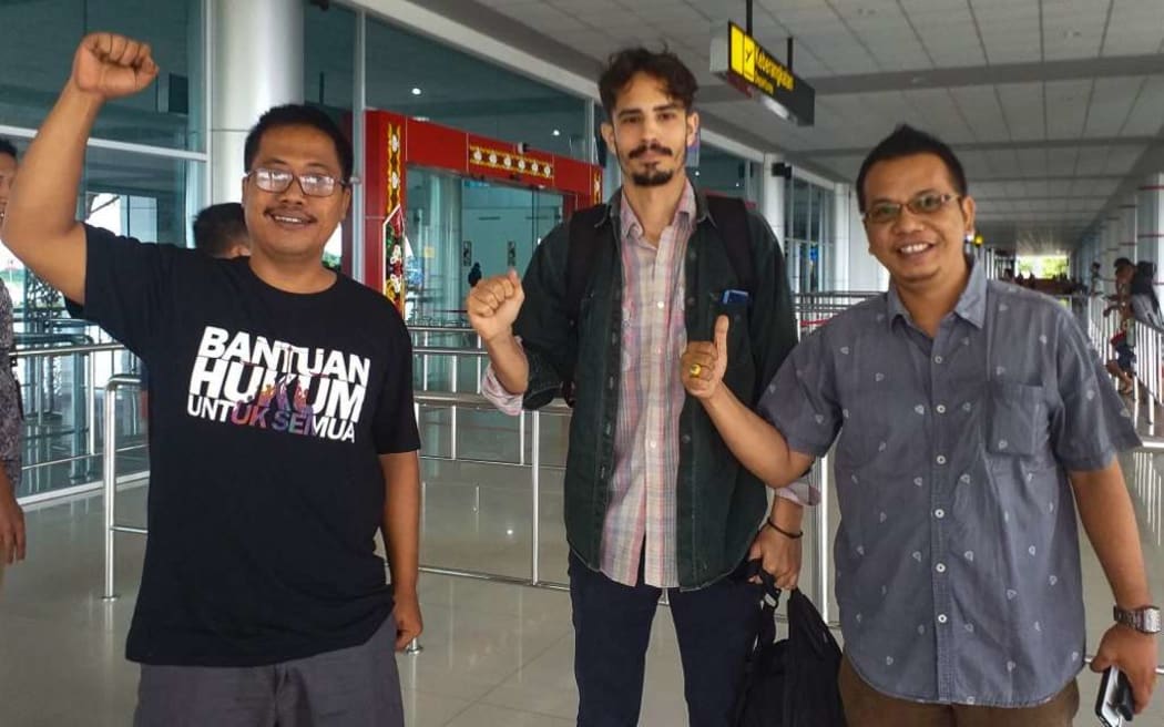 In this handout picture taken and released by Palangkaraya Legal Aid on January 31, 2020, US journalist Philip Jacobson (C) gestures next to head of Palangkaraya legal aid Aryo Nugroho Waluyo (L) and lawyer Parlin Bayu Hutabarat (R) before leaving Palangkaraya airport in Central Kalimantan.