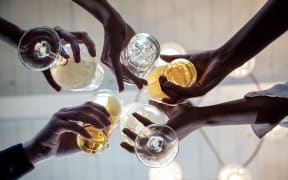 Group of friends making a toast, upward view of hands holding glasses (Photo by Gary John Norman / Connect Images / Connect Images via AFP)