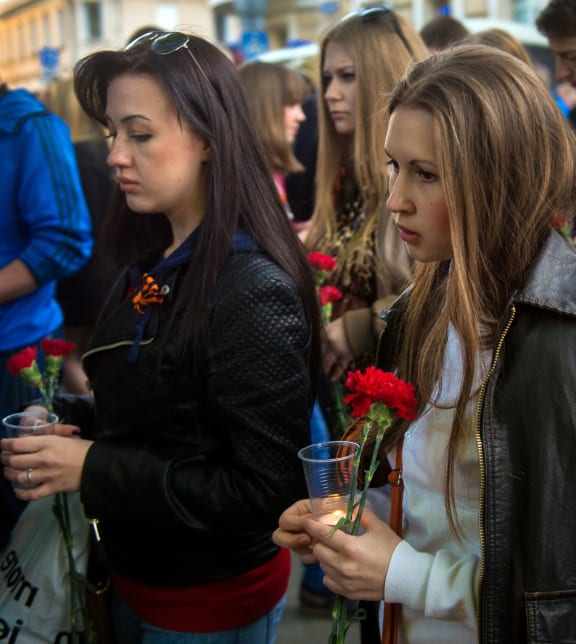 People lay flowers near the Ukrainian embassy in Moscow to honour over 30 people killed during clashes in Odessa.