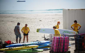 Members of the Mt Maunganui Surf Lifesaving Club moving equipment out of the building.