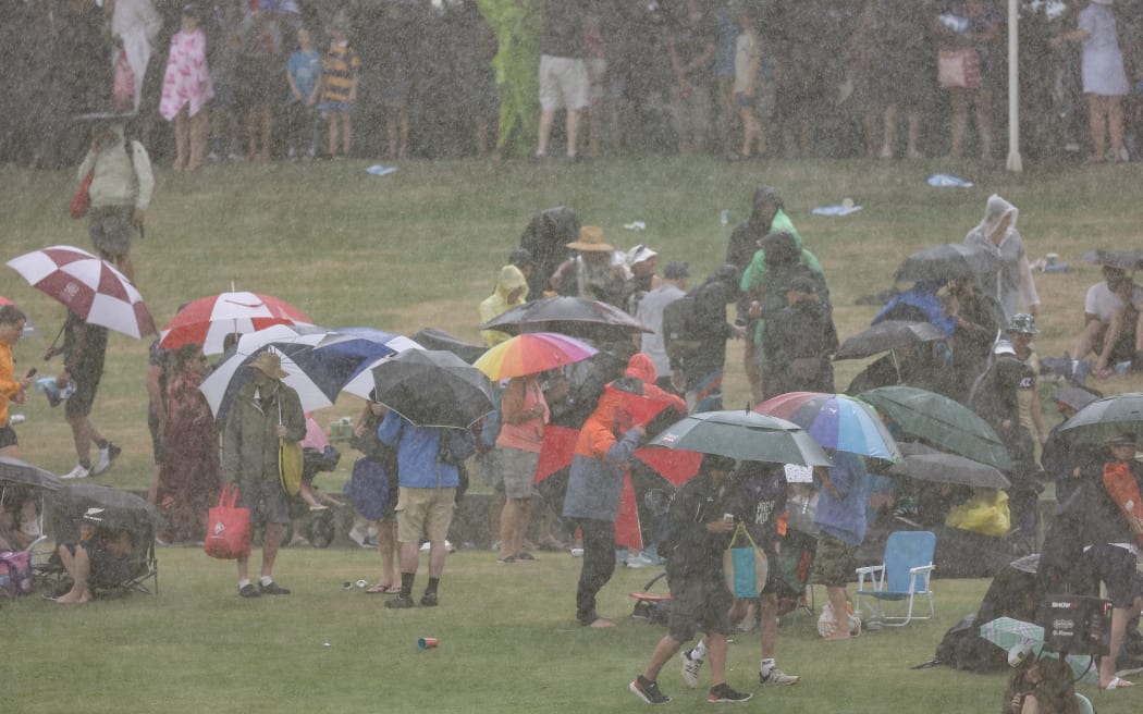 Fans try to escape the downpour during the third T20 International match between New Zealand and Bangladesh at Bay Oval in Mount Maunganui, Tauranga.