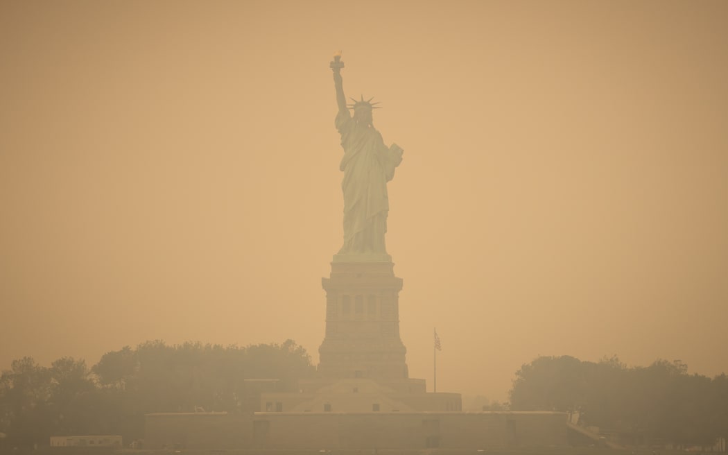 The Statue of Liberty shrouded in smoke from Canada wildfires in New York, US, on Wednesday, June 7, 2023. The US Northeast, including New York City, will continue to breathe in choking smoke from fires across eastern Canada for the next few days, raising health alarms across impacted areas. (Photo by William Volcov / BRAZIL PHOTO PRESS / Brazil Photo Press via AFP)