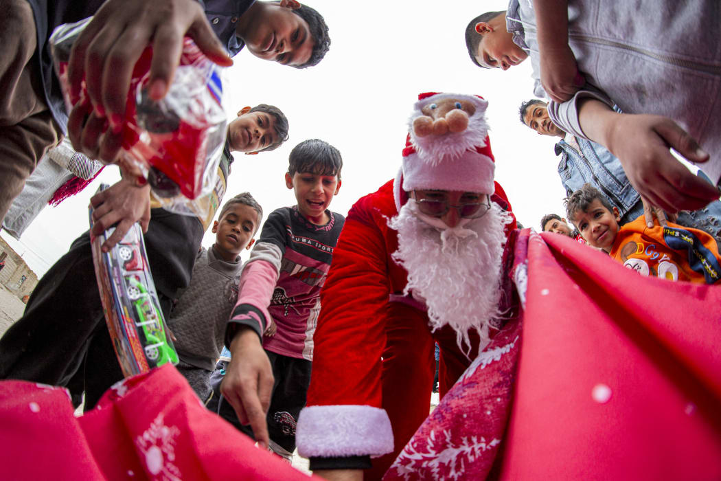 Mohamed Maarouf, 28, while dressed in Saint Nicholas, distributes Christmas gifts in the slums of Basra, Iraq.