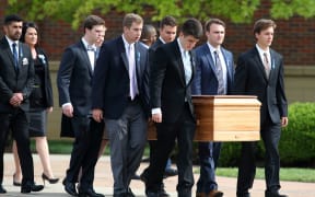The casket carrying the remains of Otto Warmbier is carried out of Wyoming High School after his funeral.