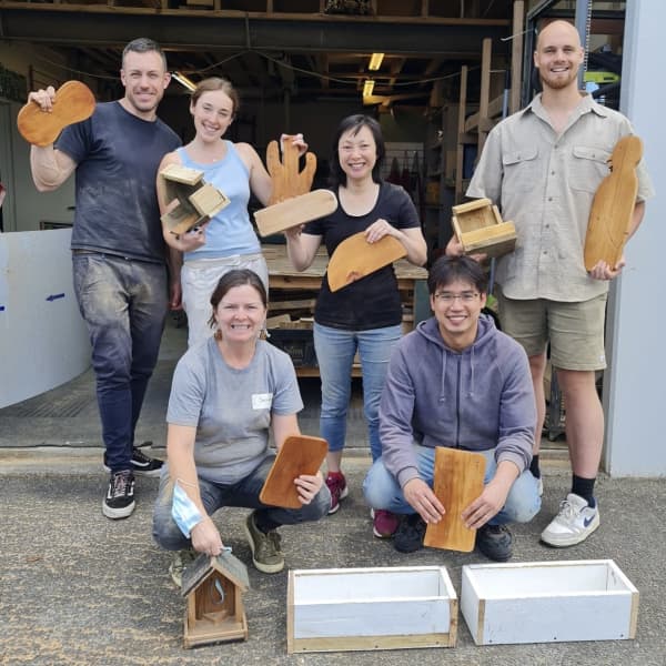 Ger Tew's The ReCreators' upcycling workshop participants show off their chopping boards.