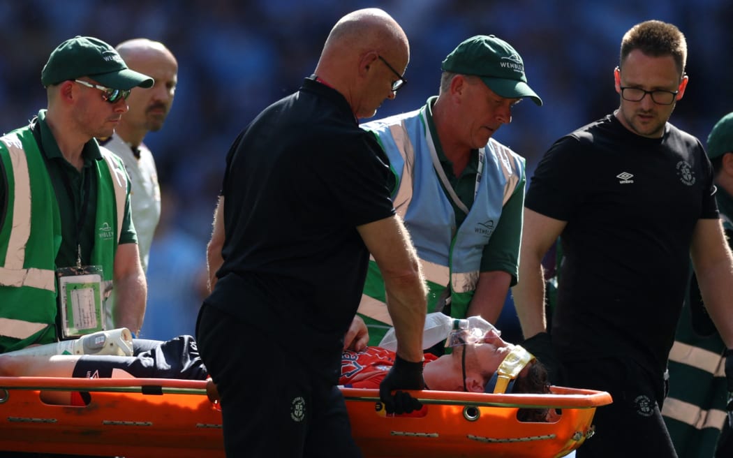 Luton Town's Welsh defender Tom Lockyer (C) is taken off on a stretcher after being taken ill during the English Championship play-off final football match between Coventry City and Luton Town at Wembley Stadium in London on May 27, 2023. (Photo by Adrian DENNIS / AFP) / NOT FOR MARKETING OR ADVERTISING USE / RESTRICTED TO EDITORIAL USE