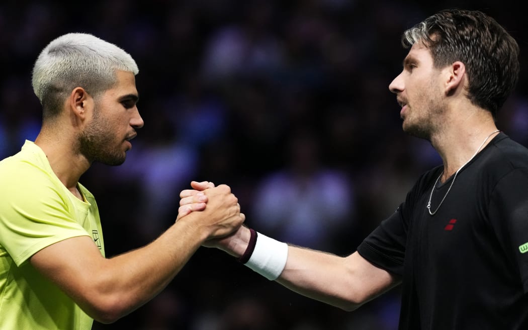 Winner Britain's Cameron Norrie (R) shakes hands with Spain's Carlos Alcaraz after their men's singles match on day two of the Paris ATP Masters 1000 tennis tournament at the Paris La Défense Arena in Nanterre, on the outskirts of Paris, on October 28, 2025. (Photo by Dimitar DILKOFF / AFP)