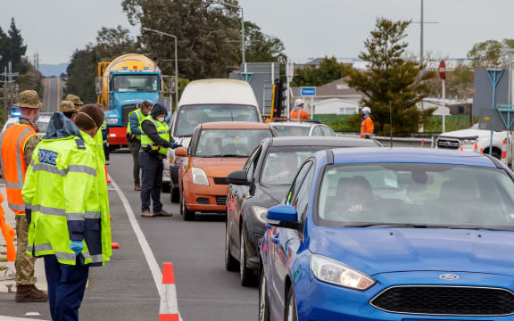 Police and military personnel check vehicles leaving the city at a COVID-19 check point setup at the southern boundary in Auckland on August 14, 2020.