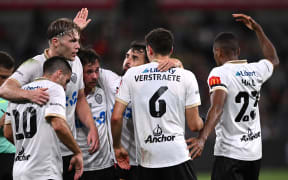 Lachlan Brook of Auckland (third left) celebrates with teammates after scoring a goal.