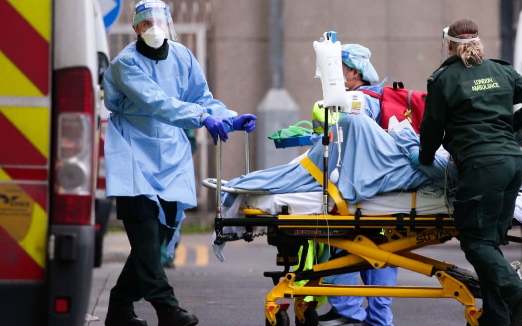 Medics wearing PPE transport a patient into the emergency department of the Royal London Hospital in London, England, on January 11, 2021.
