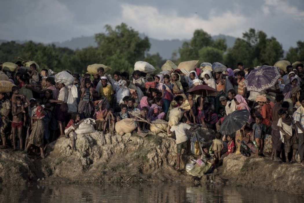 Rohingya refugees wait after crossing the Naf river from Myanmar into Bangladesh in Whaikhyang on October 9.