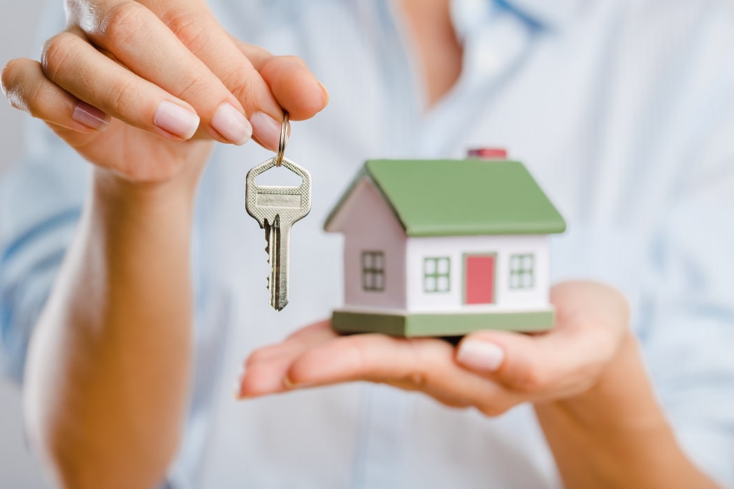 A woman holds keys to a new home.