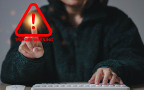Picture of a woman clicking on a 'trigger warning' icon.