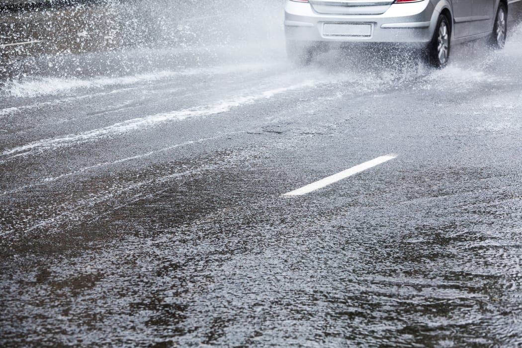 Car driving in heavy rain. Street flooding.