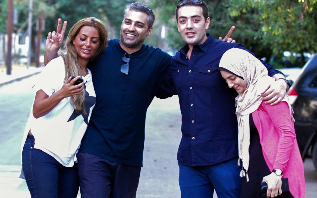 Al-Jazeera journalist Mohamed Fahmy, left, and his colleague Baher Mohamed celebrate with their wives Marwa (l) and Jihan (r) following their release from jail.