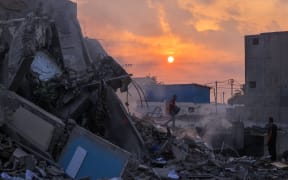 People inspect a building destroyed in Israeli strikes in Gaza City on October 8, 2023. Fighting between Israeli forces and the Palestinian militant group Hamas raged on October 8, with hundreds killed on both sides after a surprise attack on Israel prompted Prime Minister Benjamin Netanyahu to warn they were "embarking on a long and difficult war". (Photo by Mohammed ABED / AFP)