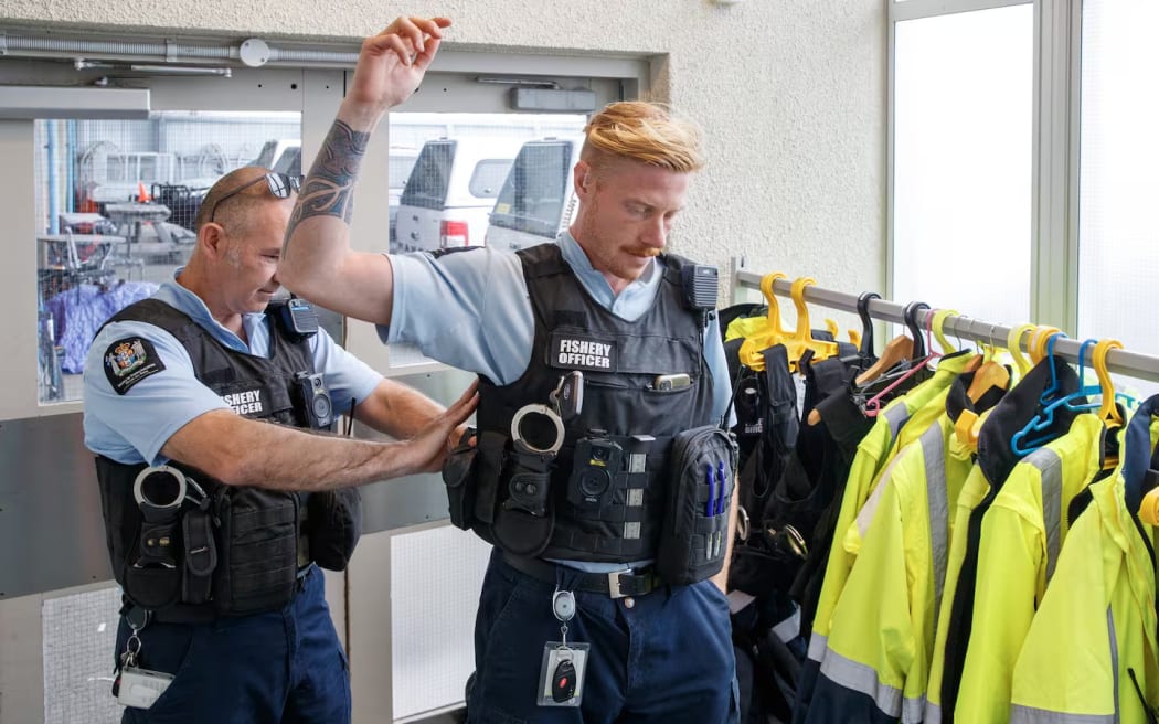 Allan Gilmour, left, helps Korban Aitken put on his stab-proof vest as they prepare to head out on patrol.