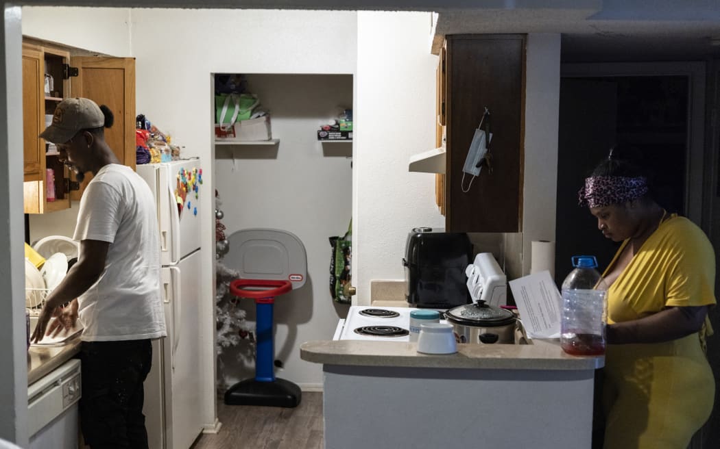 JACKSON, MS - SEPTEMBER 01: Terrence Carter, left, washes dishes while his fiancé, Jamiya Williams, right, reads about what the tap water can be used for while in their apartment on September 01, 2022 in Jackson, Mississippi. Carter and Williams water pressure increased on Wednesday however it is still not safe to drink the water. Jackson has been experiencing days without reliable water service after river flooding caused the main treatment facility to fail.   Brad Vest/Getty Images/AFP (Photo by Brad Vest / GETTY IMAGES NORTH AMERICA / Getty Images via AFP)