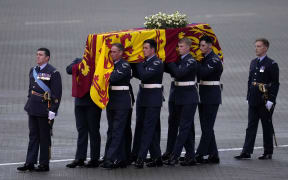 Pallbearers from the Queen's Colour Squadron (63 Squadron RAF Regiment) carry the coffin of Queen Elizabeth II to the Royal Hearse at the Royal Air Force Northolt airbase, 13 September 2022.