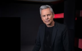 Guyon Espiner on a black background, looking at camera.