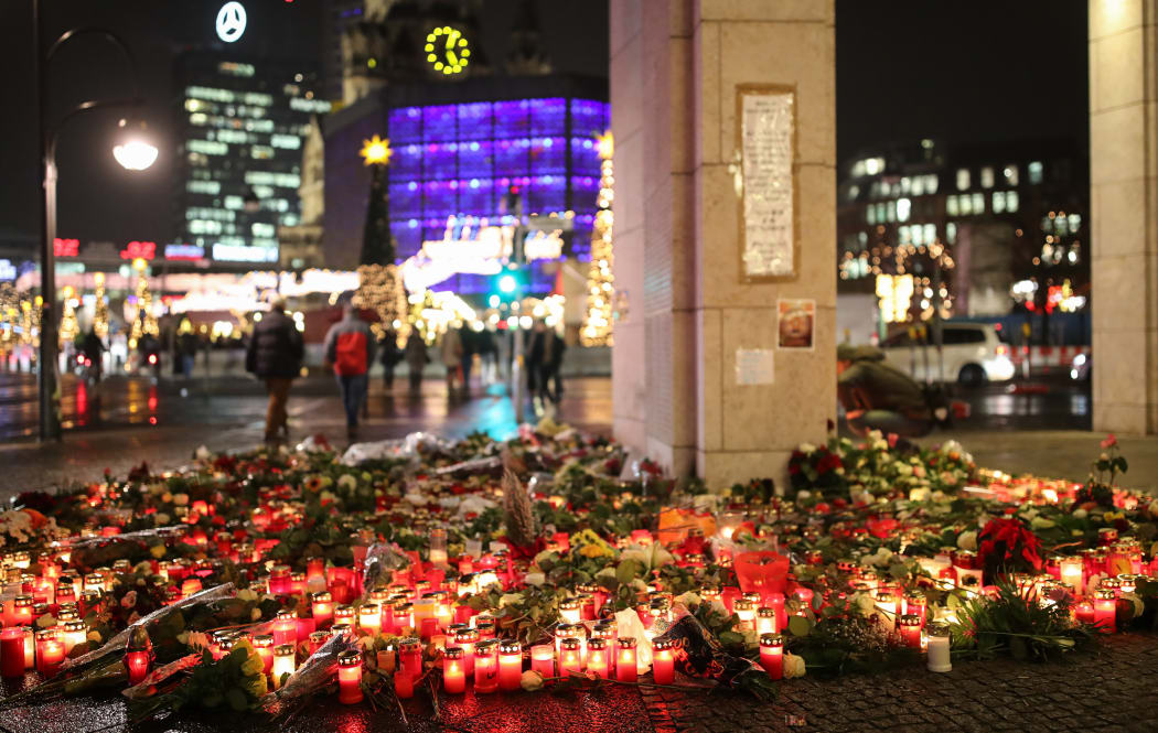 Numerous candles lie on the ground at the Christmas market on Breitscheidplatz square in Berlin, Germany, 22 December 2016. On Monday 19 December a man drove a truck into a Christmas market by the Memorial Church. At least twelve people were killed.