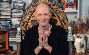 Richard O'Brien sits on a throne surrounded by Knick Knacks.